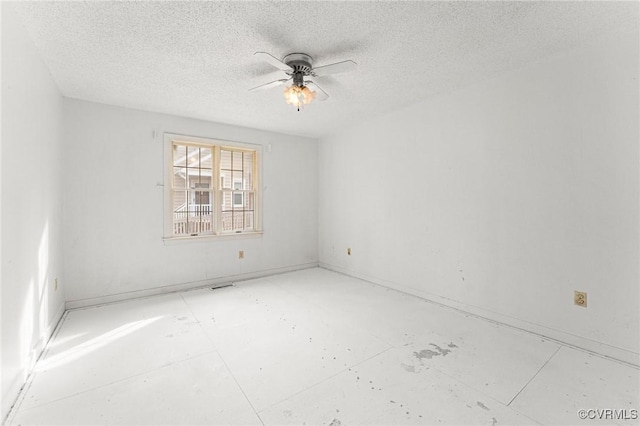 spare room with a textured ceiling and a ceiling fan