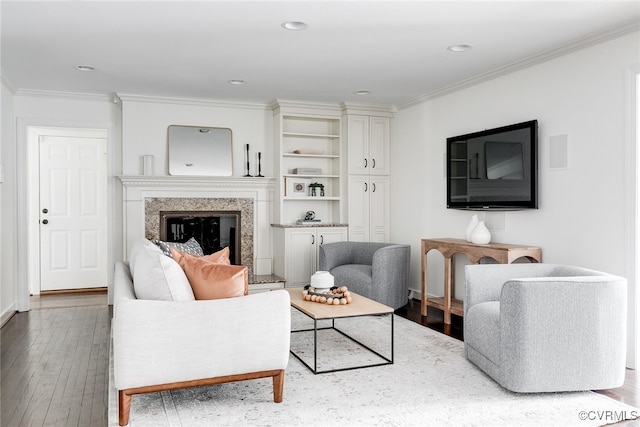 living area featuring a high end fireplace, recessed lighting, ornamental molding, and wood finished floors