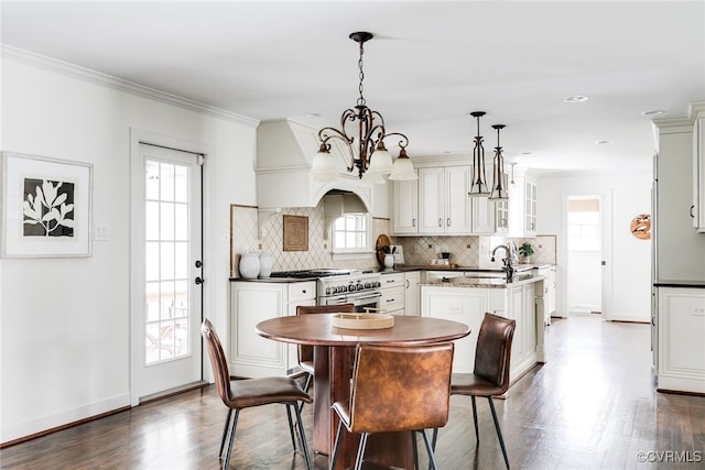 dining area with a chandelier, dark wood-style floors, baseboards, and ornamental molding