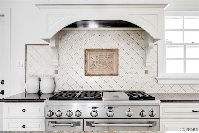 kitchen featuring white cabinetry, double oven range, and backsplash