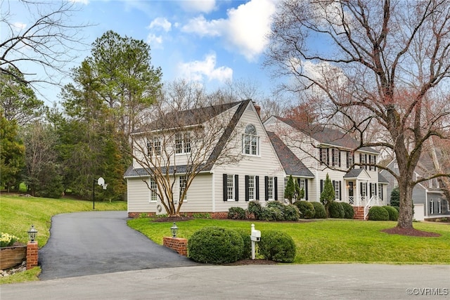 view of front of home featuring aphalt driveway and a front yard