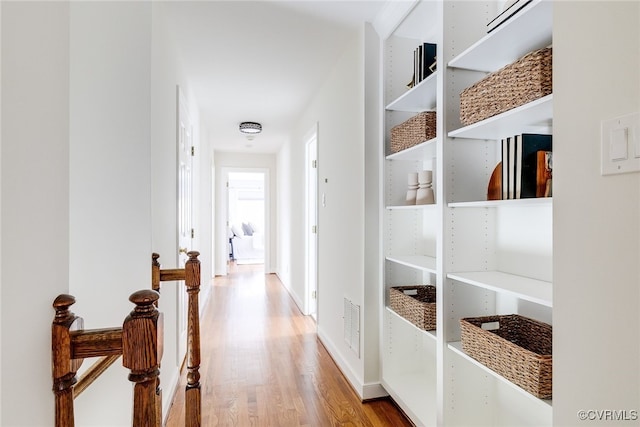 corridor featuring visible vents, wood finished floors, and baseboards