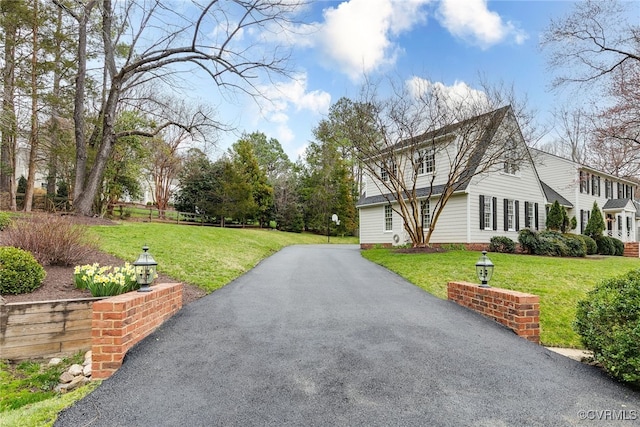 view of property exterior with driveway and a yard