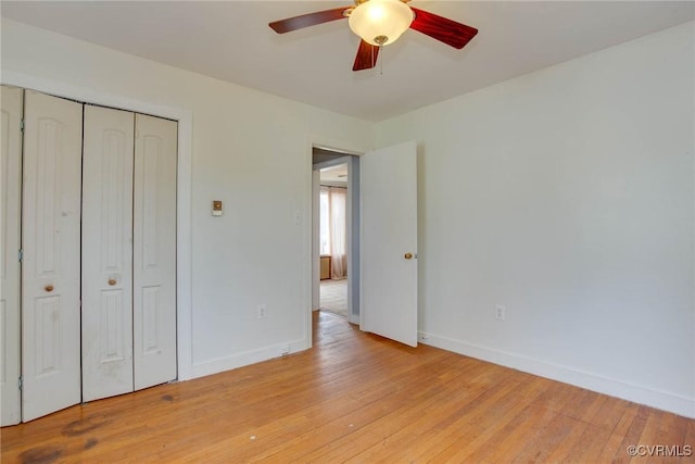 unfurnished bedroom featuring baseboards, light wood-type flooring, and a closet