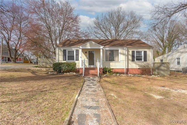 bungalow-style home featuring a front yard, fence, and crawl space