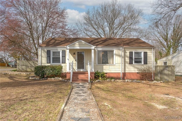 bungalow-style home featuring a front lawn and fence