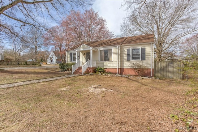 bungalow featuring a front yard and fence