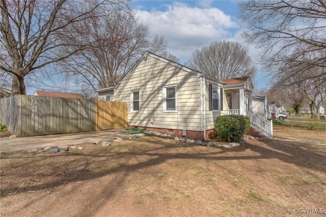 view of home's exterior with crawl space and fence