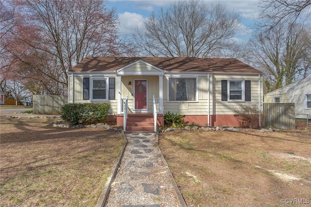 bungalow with a front lawn and fence