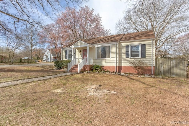 bungalow-style home with a front yard and fence