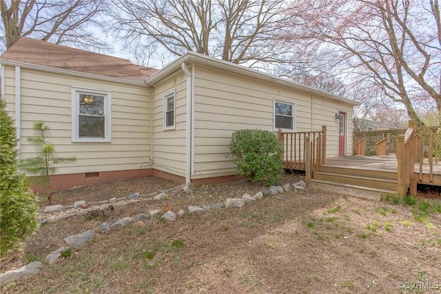 view of side of property with crawl space and a wooden deck