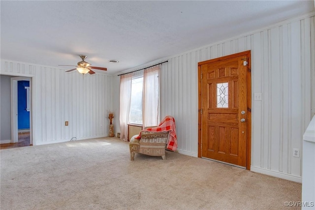 living area with visible vents, ceiling fan, and carpet floors