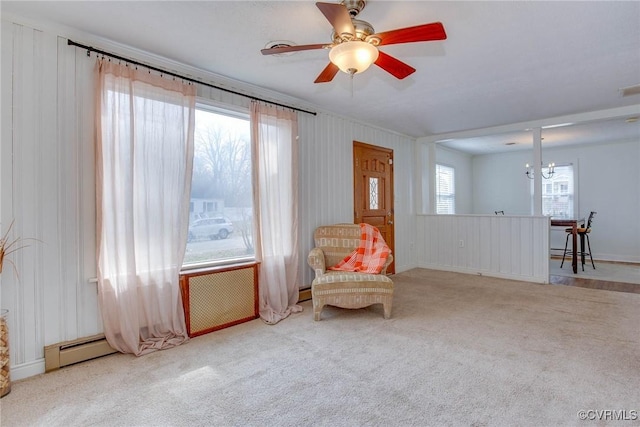 unfurnished room featuring visible vents, carpet floors, baseboard heating, and ceiling fan with notable chandelier