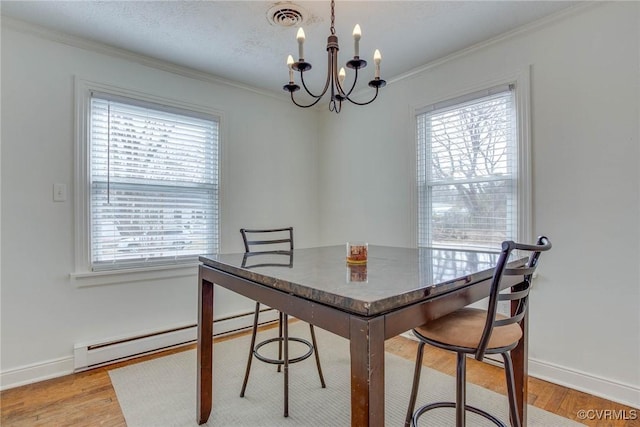 dining space with ornamental molding, an inviting chandelier, light wood finished floors, baseboards, and baseboard heating