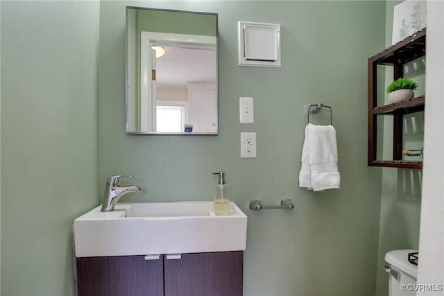 half bathroom with vanity and toilet