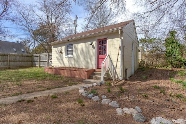 view of outbuilding featuring an outbuilding, entry steps, and fence