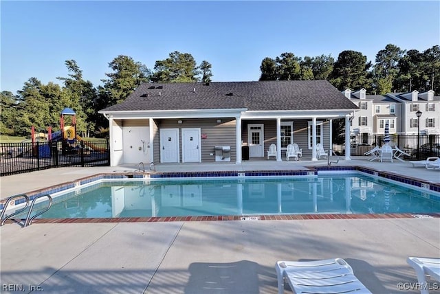 community pool featuring playground community, a patio area, fence, and grilling area