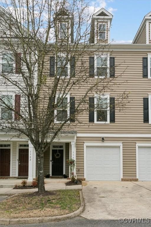 view of property with a garage and driveway