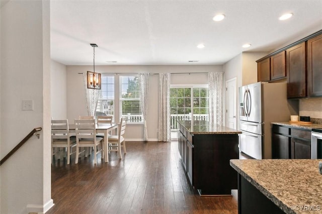 kitchen with baseboards, light stone countertops, recessed lighting, an inviting chandelier, and dark wood-style flooring