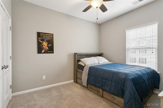 bedroom featuring ceiling fan, light colored carpet, visible vents, and baseboards