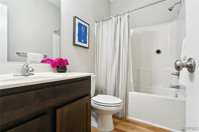 bathroom with toilet, wood finished floors, vanity, and shower / bath combination with curtain