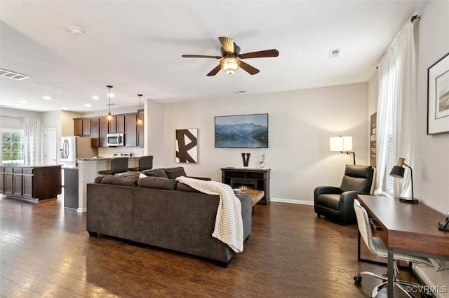 living area featuring visible vents, a ceiling fan, and dark wood-style flooring