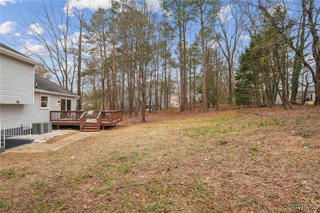 view of yard featuring central AC and a deck