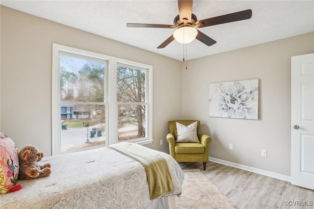 bedroom with light wood-style flooring, baseboards, and ceiling fan