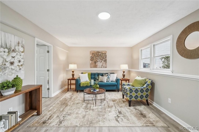 sitting room featuring baseboards and wood finished floors