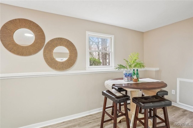 dining space featuring baseboards and wood finished floors