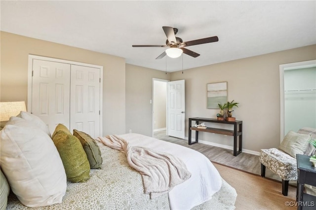 bedroom with ceiling fan, a closet, baseboards, and wood finished floors