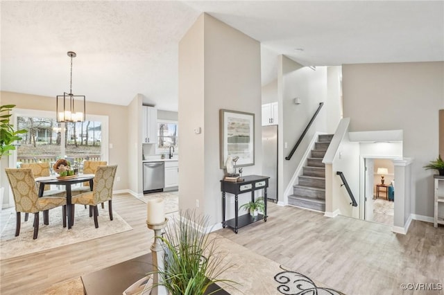 living area featuring stairs, baseboards, and light wood-type flooring