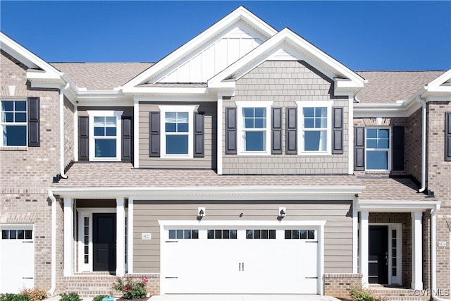 view of front facade with concrete driveway, a shingled roof, a garage, and board and batten siding