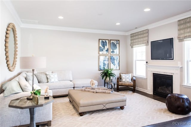 living area featuring a high end fireplace, recessed lighting, crown molding, and wood finished floors