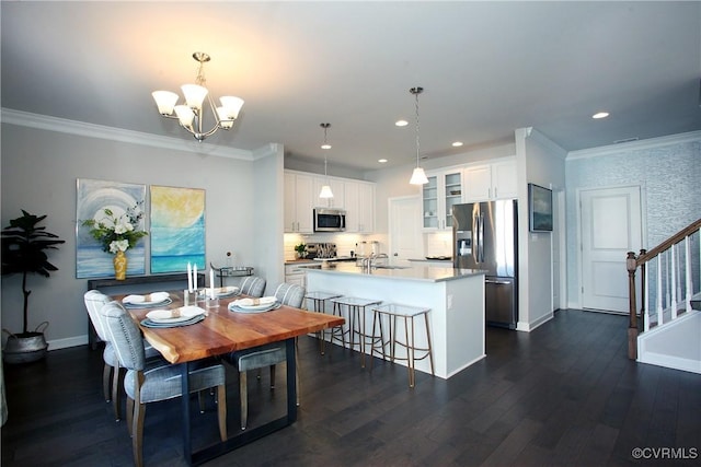 dining room featuring ornamental molding, dark wood finished floors, an inviting chandelier, baseboards, and stairs