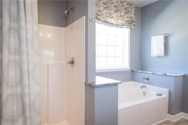 full bathroom with a shower with shower curtain and a garden tub