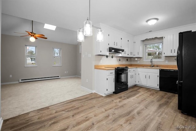 kitchen with black appliances, a ceiling fan, under cabinet range hood, a sink, and a baseboard radiator