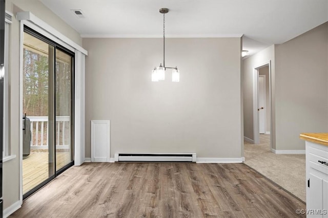 unfurnished dining area with visible vents, a baseboard heating unit, wood finished floors, an inviting chandelier, and baseboards