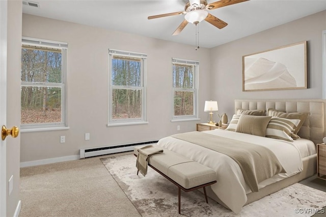 carpeted bedroom with visible vents, baseboards, baseboard heating, and ceiling fan