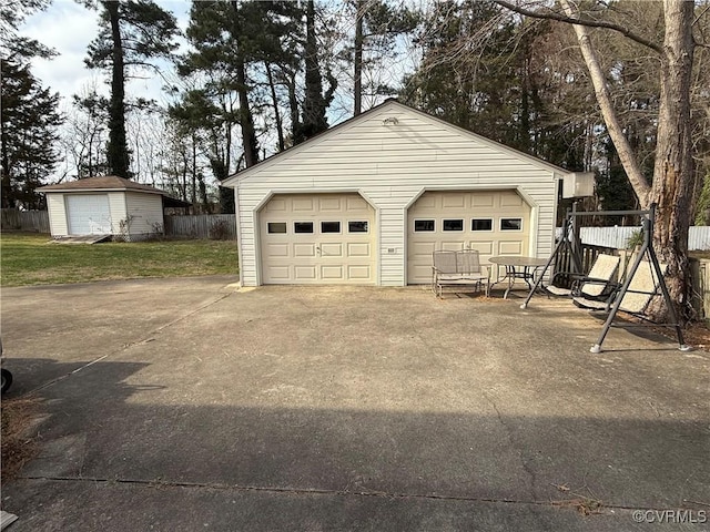 detached garage featuring fence