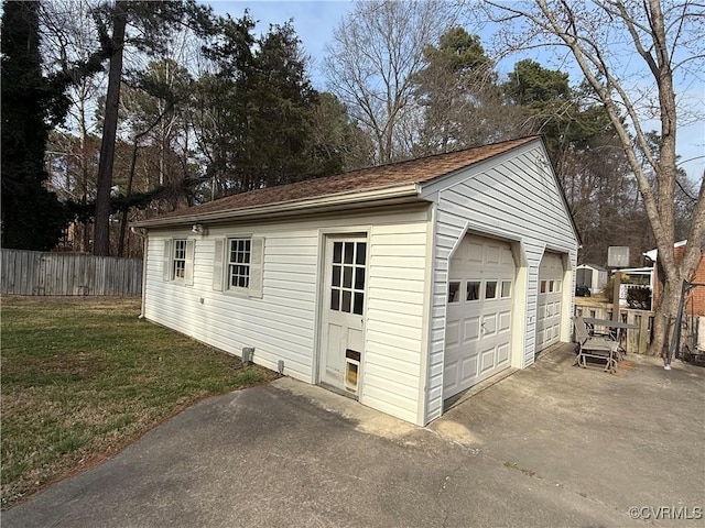 detached garage featuring fence