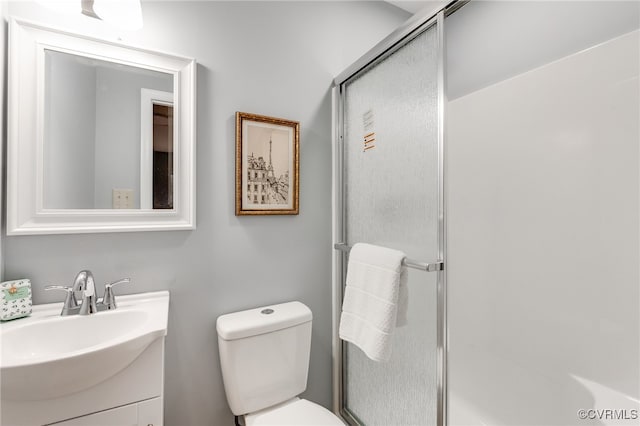 full bathroom with vanity, a shower stall, and toilet