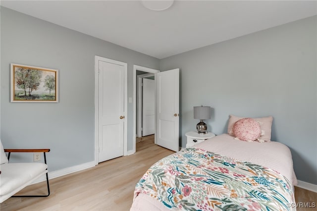 bedroom featuring baseboards and light wood finished floors