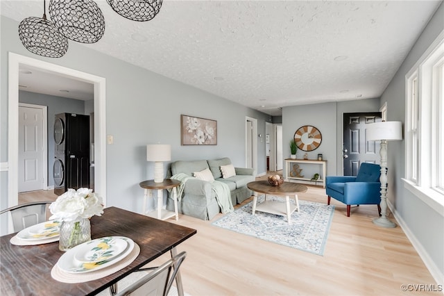 living area featuring a textured ceiling, baseboards, and wood finished floors