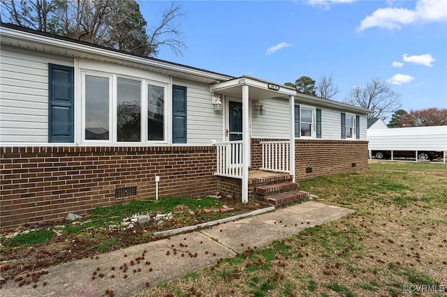 view of front of property featuring crawl space, brick siding, and a front lawn