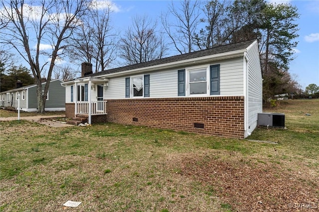 view of front of home featuring a front yard, cooling unit, a chimney, crawl space, and brick siding