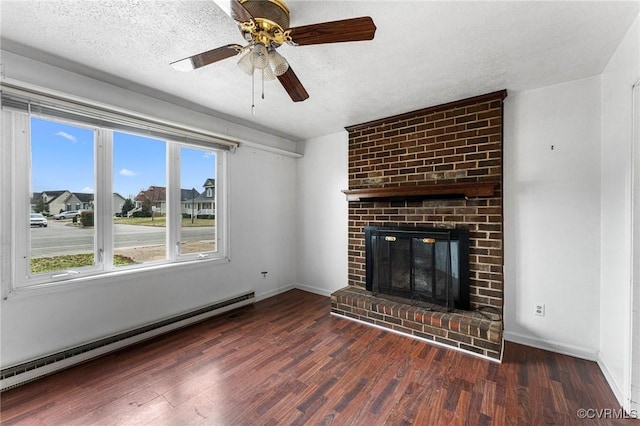 unfurnished living room with baseboard heating, wood finished floors, a fireplace, and a textured ceiling