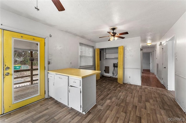 kitchen with dishwasher, a peninsula, a ceiling fan, and dark wood finished floors