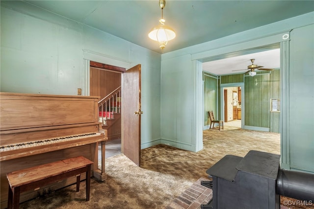 sitting room featuring stairs, ceiling fan, and carpet flooring