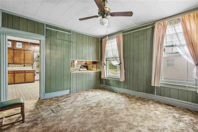 empty room with visible vents, a ceiling fan, and carpet